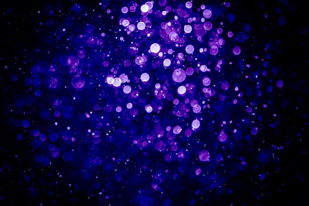 Blurred photo with purple violet and blue dots visible glittering, shining brightly look and feel luxurious Suitable for use as a wallpaperの写真素材