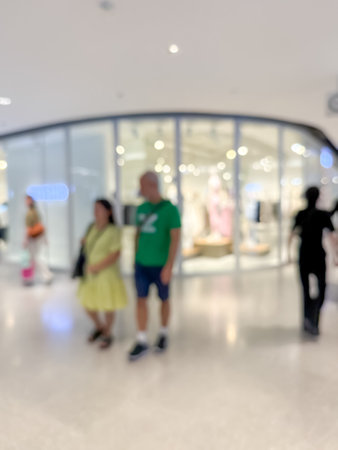 blurred image of a bustling shopping mall, capturing the vibrant atmosphere of a modern retail environment. People are seen shoppingの写真素材