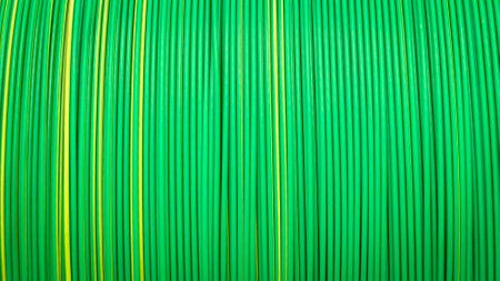 Colorful, tightly coiled green and yellow plastic cables in symmetry.の写真素材