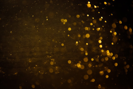 Blurred photo with golden dots visible glittering, shining brightly look and feel luxurious Suitable for use as a wallpaper showing luxury and taste.の写真素材