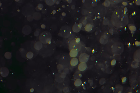 Defocused bokeh lights of different sizes and colors on a dark background.の写真素材