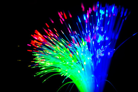 Close up of blurred light fiber optics for communication technology network on black backgroundの写真素材