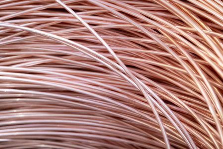 Close-up of coiled copper wires with a shiny surface, intricate overlapping pattern, warm lighting.の写真素材