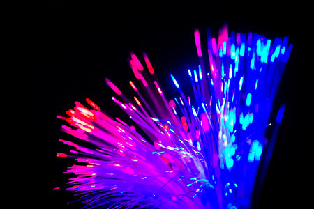 Close up of blurred light fiber optics for communication technology network on black backgroundの写真素材