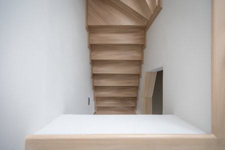 A modern, light-toned wooden staircase inside a contemporary home, showcasing clean lines and minimalistic design.の写真素材