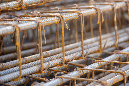 Close-up of steel rebar grid used for concrete reinforcement in construction. Showing a pattern of rusty bars, essential for building strength.の写真素材