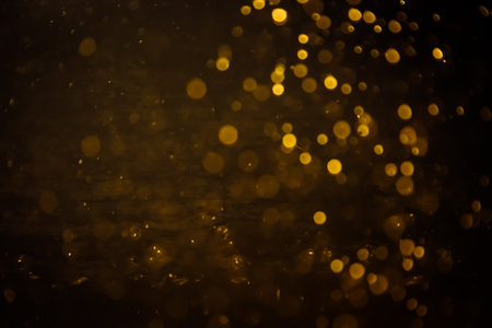 Blurred photo with golden dots visible glittering, shining brightly look and feel luxurious Suitable for use as a wallpaper showing luxury and taste.の写真素材