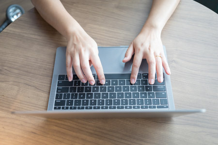 Working from home on laptop while typing chat to customer communicates on internet in home office, Concept of remote work e-learning business from homeの写真素材