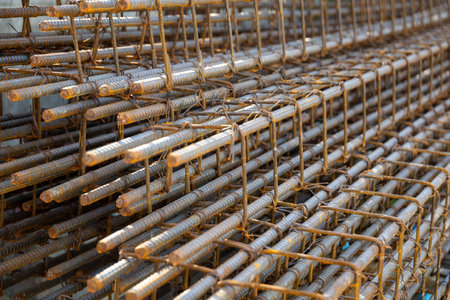 Close-up of steel rebar grid used for concrete reinforcement in construction. Showing a pattern of rusty bars, essential for building strength.の写真素材