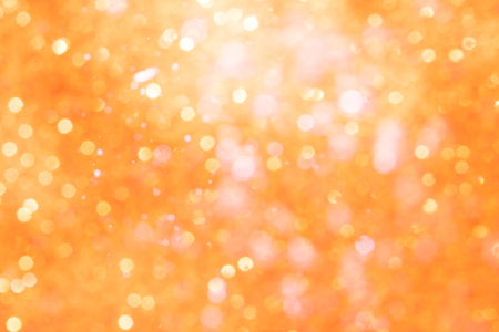 Orange abstract sparkles or glitter lights Defocused circles bokeh backgroundの写真素材