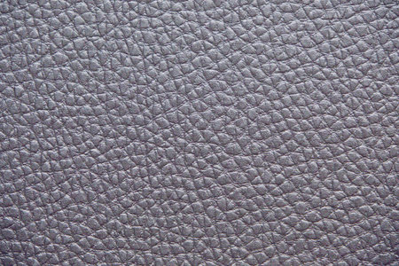 close-up of a soft Textured Purple Leather.  The surface is covered in small, evenly spaced grains, giving it a smooth and luxurious appearance. The neutral color and natural texture make it a versatile backgroundの写真素材