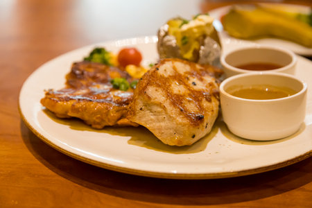 Grilled pork steak served with mashed potatoes and vegetablesの写真素材