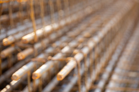 Close-up of steel rebar grid used for concrete reinforcement in construction. Showing a pattern of rusty bars, essential for building strength.の写真素材