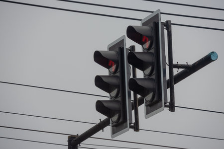 A close-up view of two traffic light signals showing red. The illuminated red lights indicate stop...