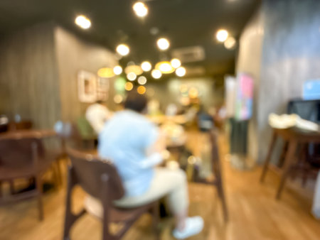 blurred image of a busy cafe interior with customers. Creates an abstract and atmospheric view of the social settingの写真素材