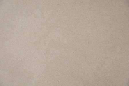 A high-resolution close-up of a brown kraft paper texture, featuring a natural and slightly rough surface. Ideal for use as a backgroundの写真素材