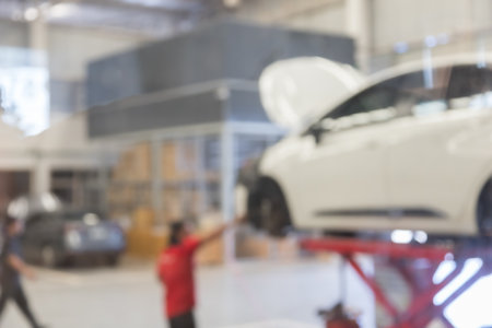 blured image of car service centre auto repair workshop use for backgroundの写真素材