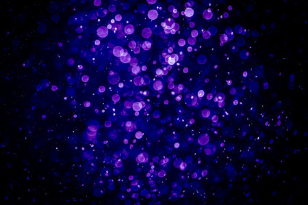 Abstract purple bokeh on black background.の写真素材