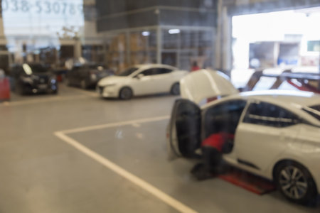 blured image of car service centre auto repair workshop use for backgroundの写真素材
