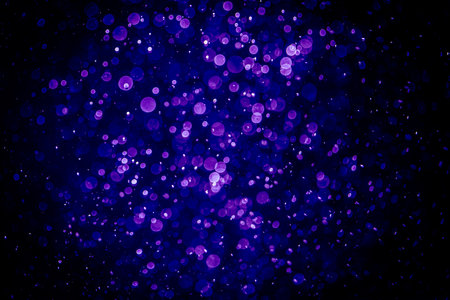 Purple bokeh lights on black background. Abstract texture.の写真素材