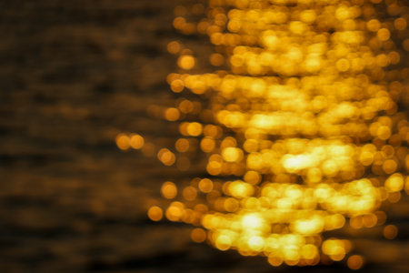 blurred bokeh effect abstract image capturing the golden reflections of sunlight on water, creating a dreamyの写真素材