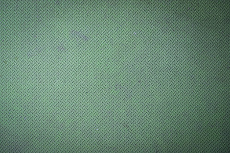 Green diamond plate metal surface with visible wear and scratchesの写真素材