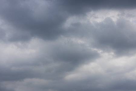 overcast sky filled with dark and light gray clouds, conveying a sense of moodiness and impending...