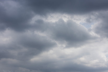 overcast sky filled with dark and light gray clouds, conveying a sense of moodiness and impending...
