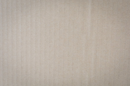 Textured beige corrugated cardboard surface with vertical ridges and subtle shading.