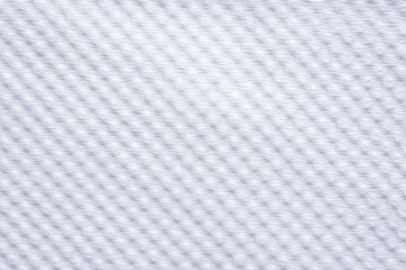 close-up of a white woven fabric, showcasing its delicate, uniform texture and subtle shadows. Perfect for clean backgrounds.の写真素材