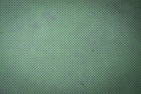Green diamond plate metal surface with visible wear and scratchesの写真素材