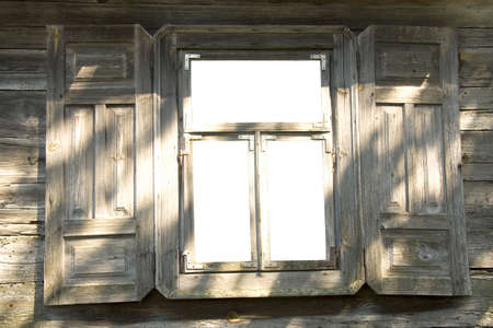Old wooden open window with white glasses and with the opened shuttersの写真素材