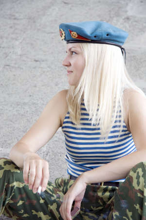 The woman in the military form sits and smokesの写真素材