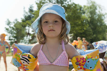 little girl costs on a beach in the summer in oversleeves and is ready to learn to float
の写真素材