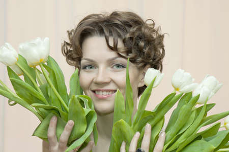 joyful woman with a bouquet of white tulipsの写真素材