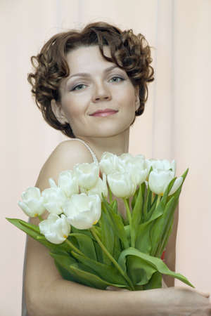 joyful woman with a bouquet of white tulipsの写真素材