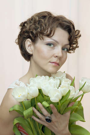 woman with tenderness holds a bouquet of white tulipsの写真素材