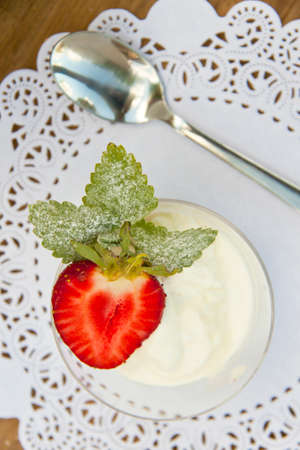 Fresh strawberry with ?????????? on a table; a metal spoon for a dessertの写真素材