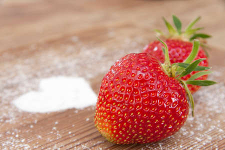 Fresh strawberry with sugar on a wooden tableの写真素材