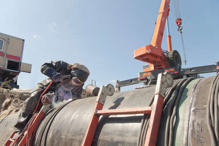 person welds a pipe; pipe welding; works on repairの写真素材