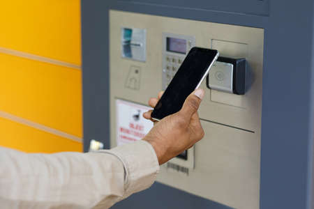 Man client using automated self service post terminal machine or locker. Mail shipping concept