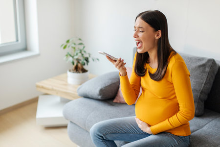 Pregnancy cramps. Pregnant woman screaming, touching belly while calling emergency, making call to...