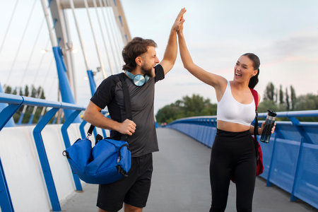 Motivation and sport achievement. Man and woman giving high five to each other after workout...