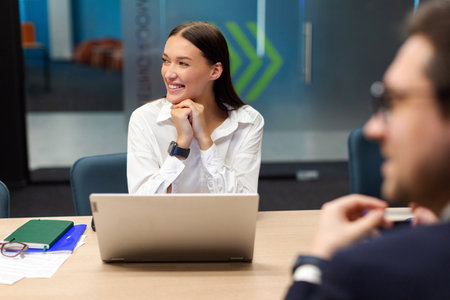 Cheerful businesspeople listening presentation in office boardroom, business professionals sitting...