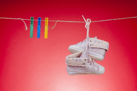 Children's shoes are drying on a ropeの写真素材