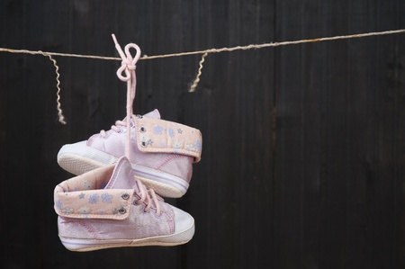 Children's shoes are drying on a ropeの写真素材