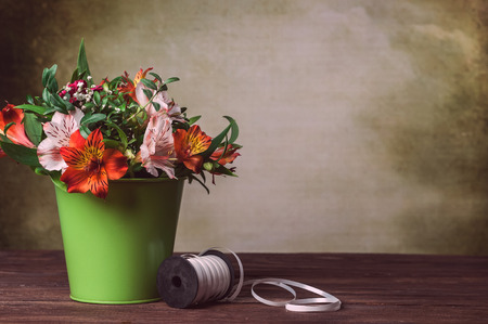 alstroemeria in bucket on old backgroundの写真素材