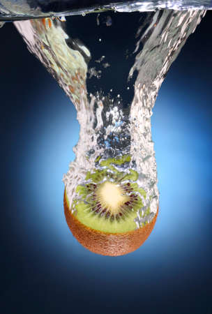 juicy kiwi with splashes of waterの写真素材