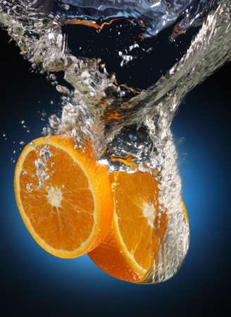 juicy orange with splashes of waterの写真素材