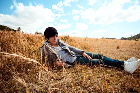 Young man rest on golden field.の写真素材